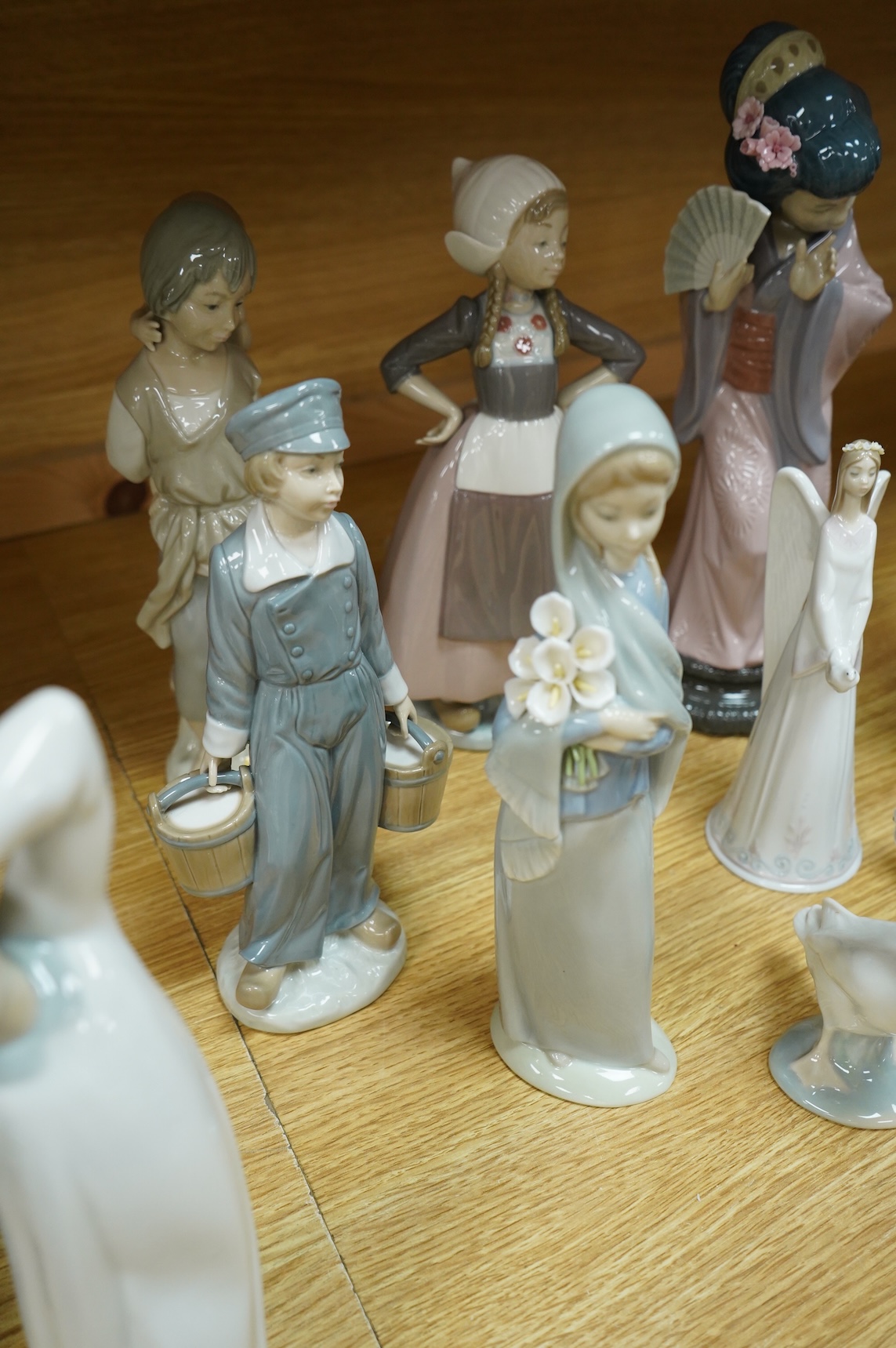A group of Lladro figurines including: a Japanese Geisha, a model of Christ, 3 birds, various children, an angel bell etc. (all boxed) (13)